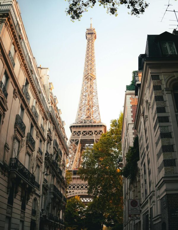 Iconic Eiffel Tower surrounded by classic Parisian buildings during a serene sunset.